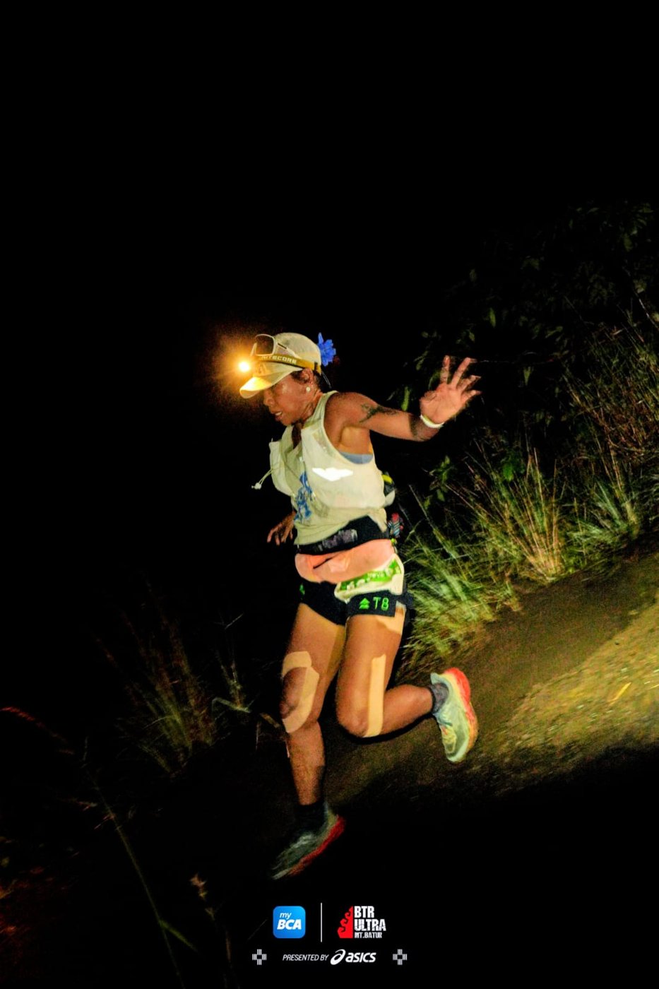 Trisha trail running at night with a headlamp