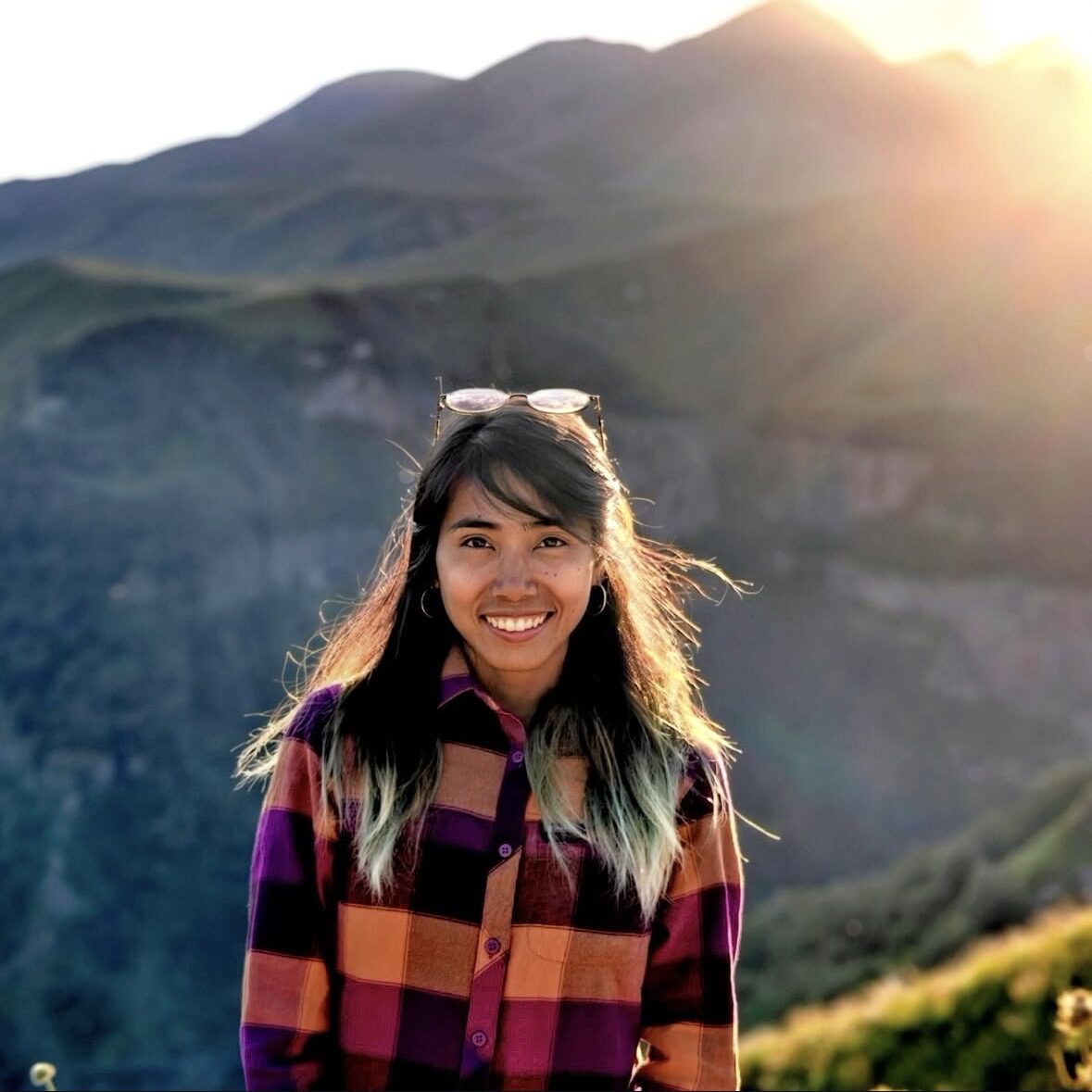 Trisha Reyes smiling in the mountains at golden hour
